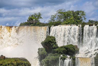 Scenic view of waterfall against sky