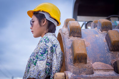 Female architect standing by bulldozer