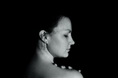 Close-up of a woman over black background