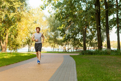 Full length of man running on footpath in park