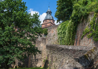 Low angle view of trees and building against sky