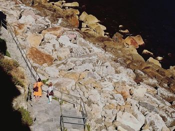 Man standing on rock formation against sky