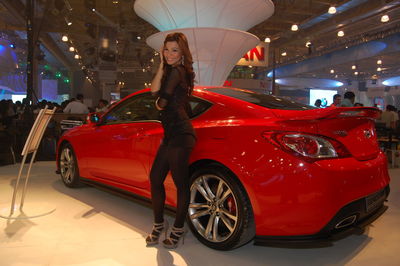 Full length portrait of woman standing in car