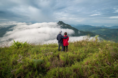 Rear view of man on mountain against sky