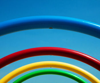 Multi colored carousel against clear blue sky