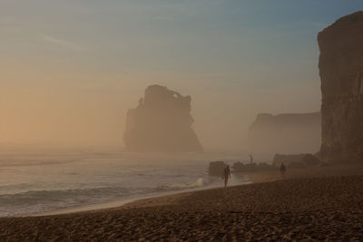 Silhouette of people standing on beach