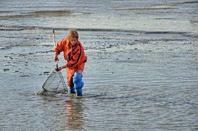 Boy fishing in muddy lake