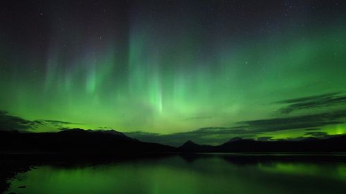 Scenic view of lake against sky at night