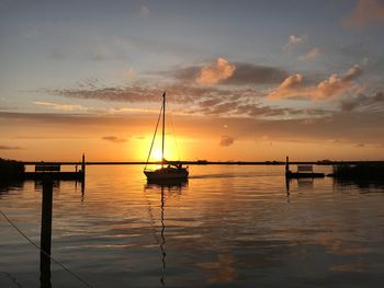 Silhouette sailboats on sea against sky during sunset