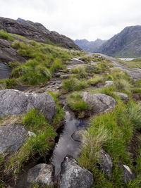 Scenic view of river by mountains against sky