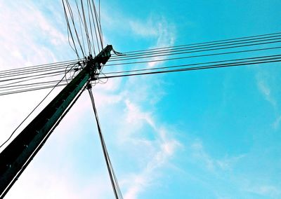 Low angle view of electricity pylon against blue sky