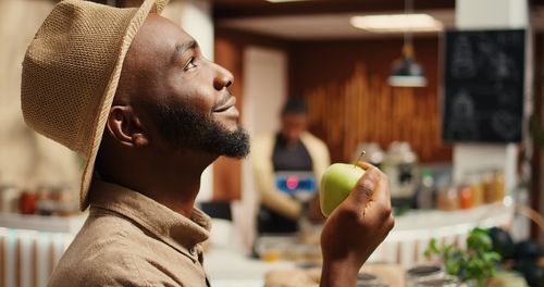 Side view of man drinking milk at home