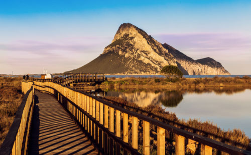 Scenic view of lake by mountain against sky