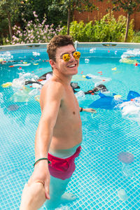 Midsection of shirtless man in swimming pool