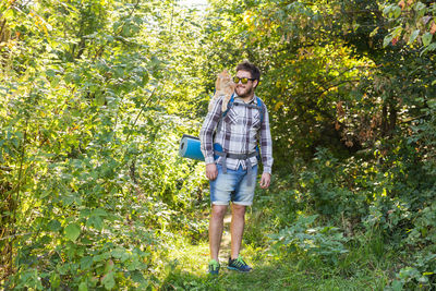 Full length of a man standing against trees