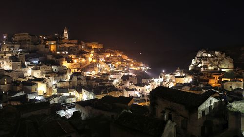 Illuminated cityscape against sky at night