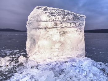 Icy winter landscape - thick ice covered ashore. crashed ice floe on frozen sea in within sunset