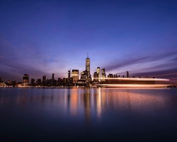 Reflection of illuminated buildings in city at dusk