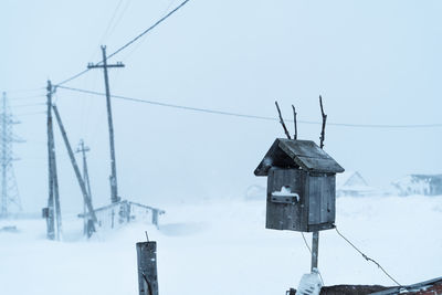 Low angle view of communications tower against sky during winter