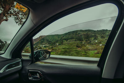 Scenic view of mountains seen through car window