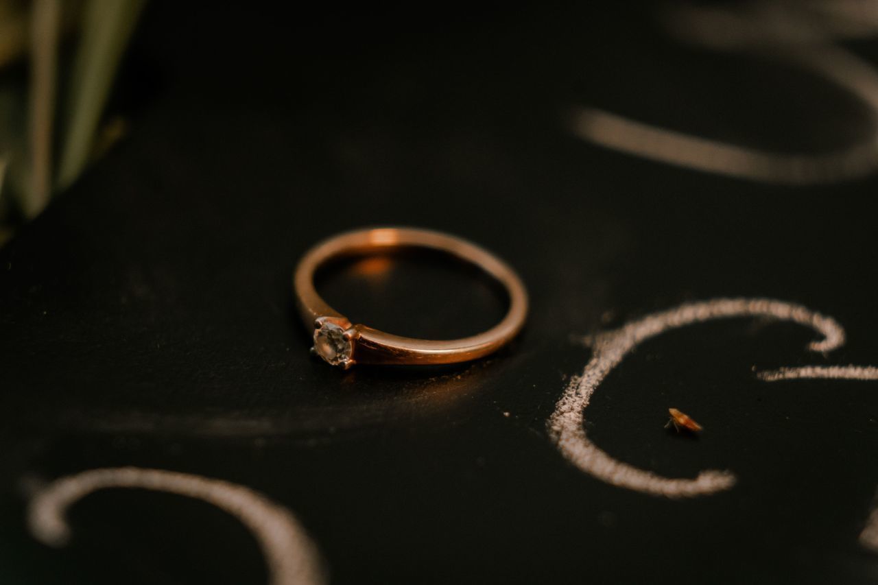 HIGH ANGLE VIEW OF WEDDING RINGS ON METAL TABLE