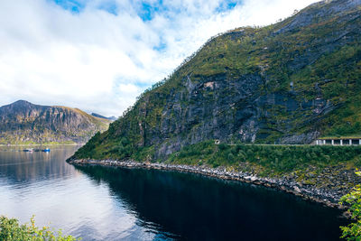 Scenic view of lake by mountains against sky