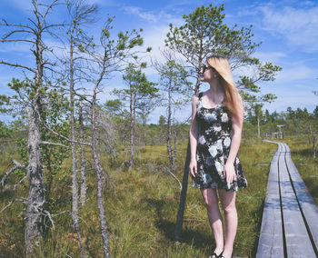 Full length of woman standing on field against sky