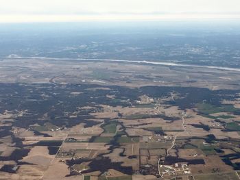 Aerial view of agricultural field in city against sky