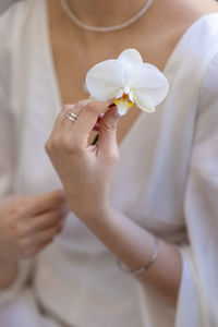 Midsection of woman holding flower