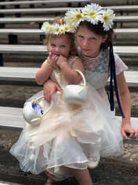 Portrait of girl with sister wearing flowers on hair