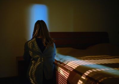 Rear view of woman standing at home