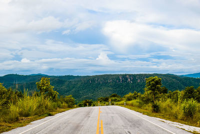 Empty road along landscape and mountains against sky