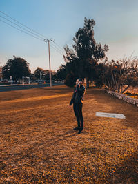 Full length of woman walking on field against sky