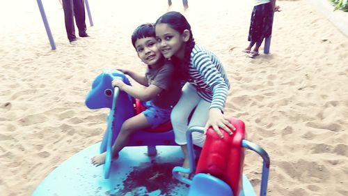 Portrait of happy friends sitting on beach