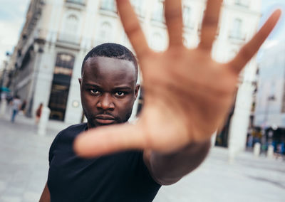 Man protesting at a rally for racial equality raising arms showing hand to camera. black lives matter.