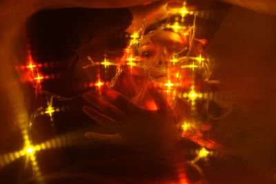 Digital composite image of woman holding illuminated fire