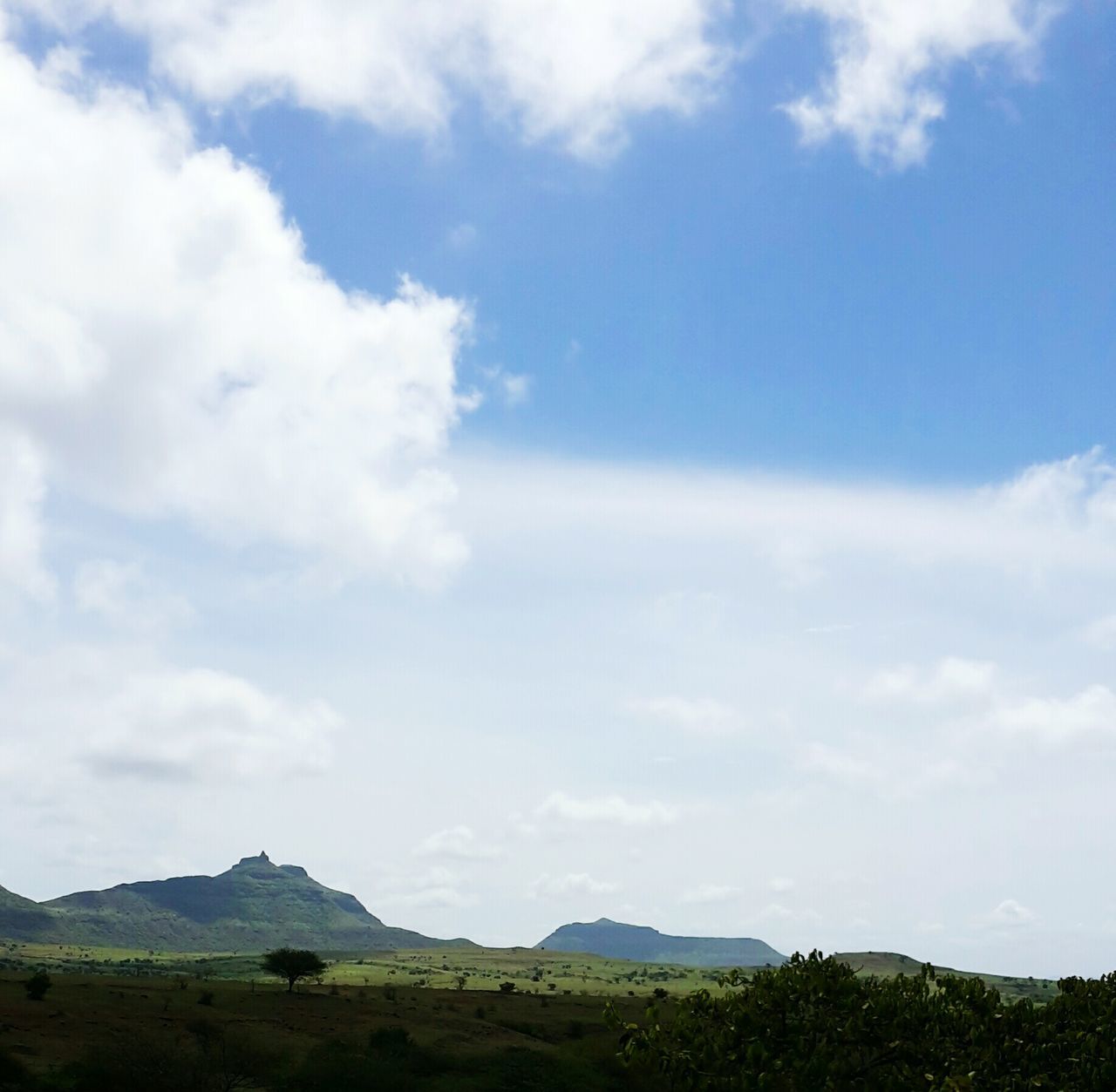 sky, tranquil scene, tranquility, scenics, mountain, landscape, cloud - sky, beauty in nature, cloud, nature, blue, non-urban scene, cloudy, mountain range, idyllic, day, remote, outdoors, hill, tree