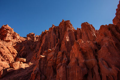 Rock formations on mountain against blue sky