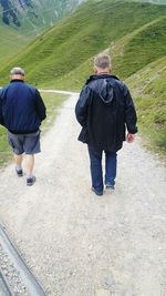 Rear view of man and woman walking on road