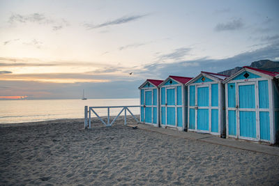 Beach hut against sky during sunset