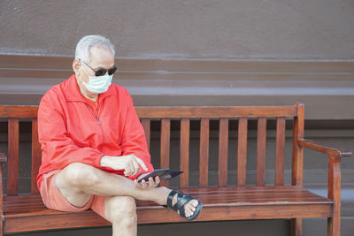 Old elder senior man elderly  wearing face mask using mobile smart phone. retirement lifestyle