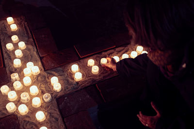 High angle view of woman holding lit candles