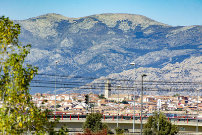 Townscape by mountains against clear sky