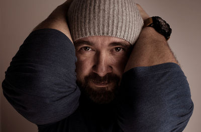 Portrait of man wearing hat against gray background