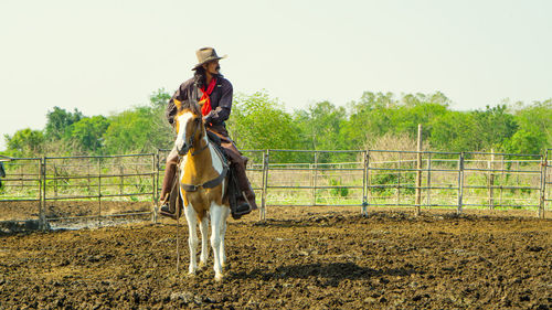 Full length of man riding horse on field