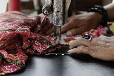 Cropped hands of woman sewing at workshop