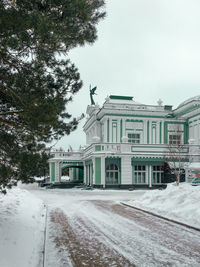 Buildings by street against sky during winter