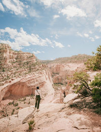 Rear view of woman walking on mountain against sky