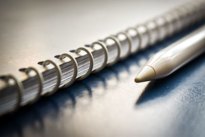 Close-up of digitized pen and spiral notebook on table