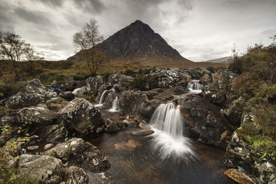 Scenic view of waterfall against sky